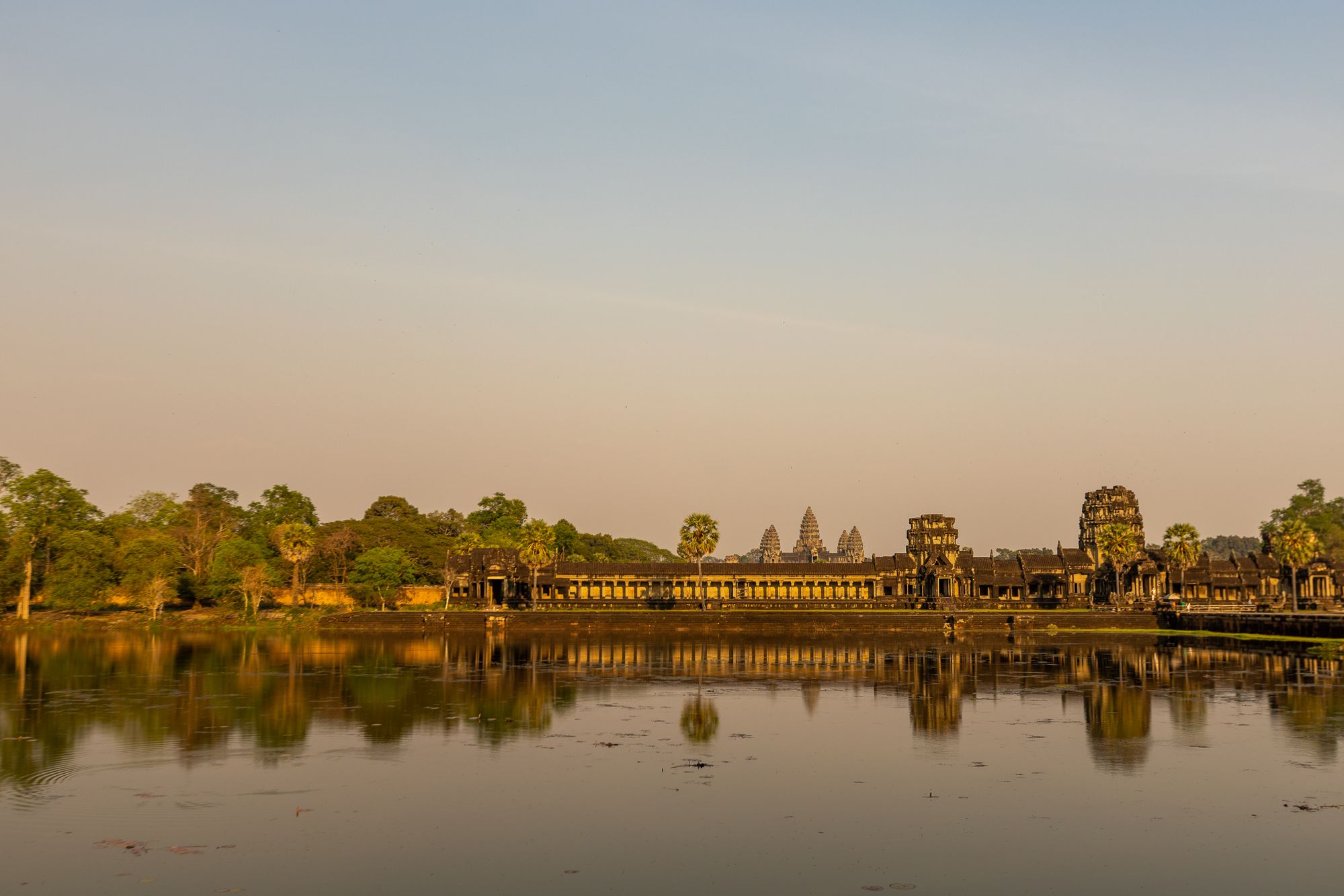 The five towers of Angkor Wat mirrored in the temple moat at sunrise